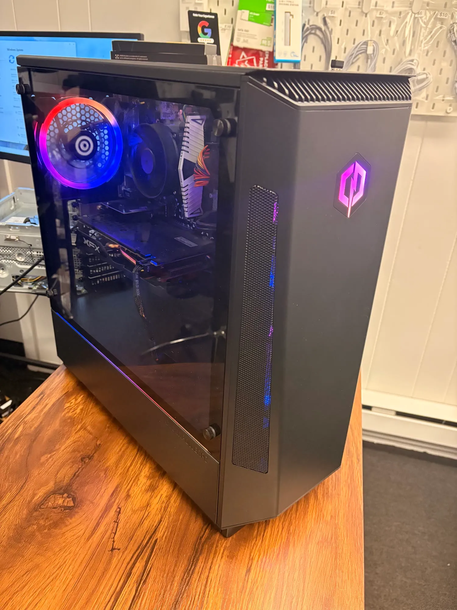 A black gaming tower with RGB lighting on the shop counter