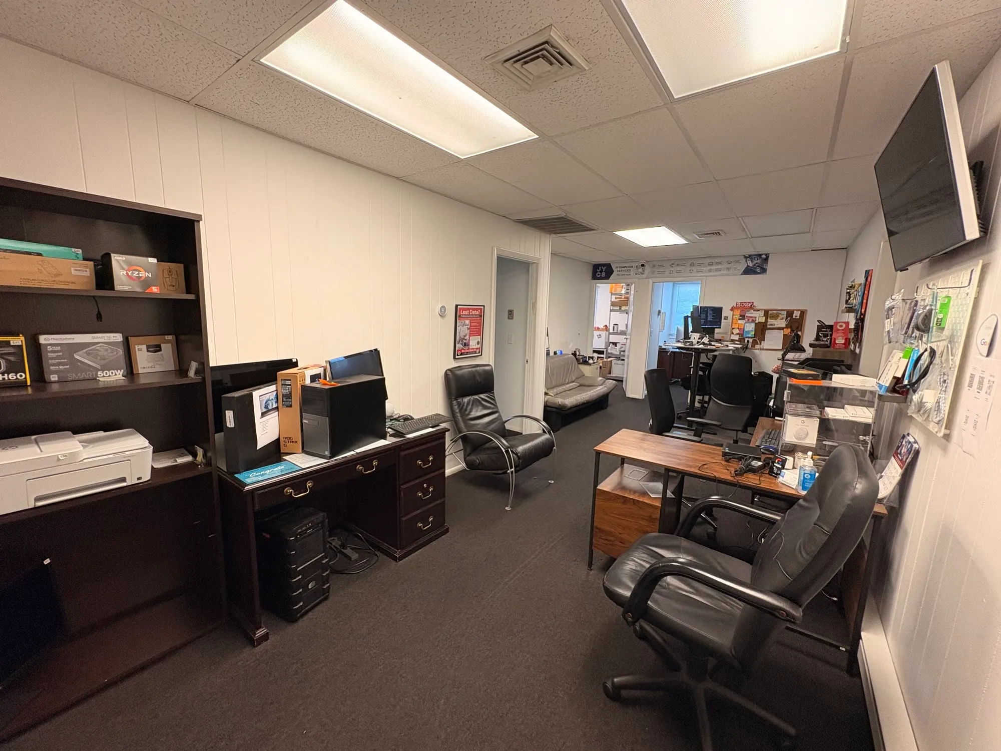 Inside the JY Computer Services shop in Marlboro — workbenches, parts shelves and the branded banner